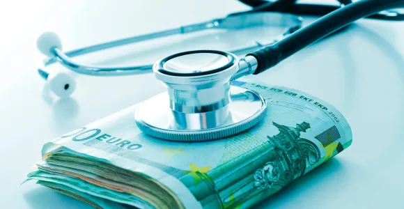 Une liasse de billets sur laquelle est posé un stéthoscope