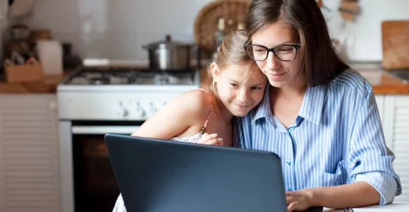 Une mère et sa fille consultent quelque chose sur un ordinateur portable
