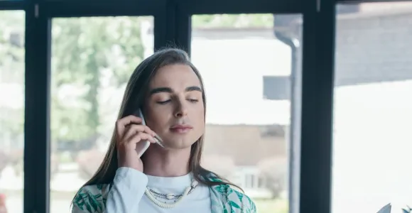 transgenre femme au téléphone avec un classeur ouvert dans l'autre main