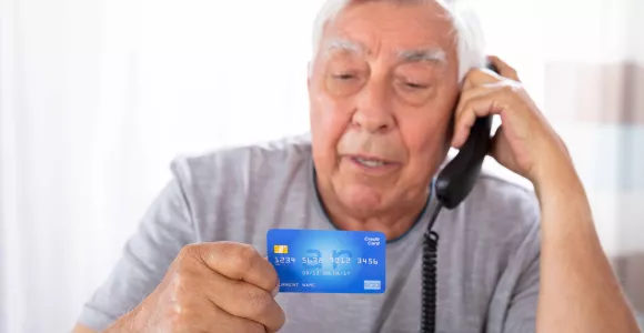 Monsieur au téléphone avec carte bancaire en main