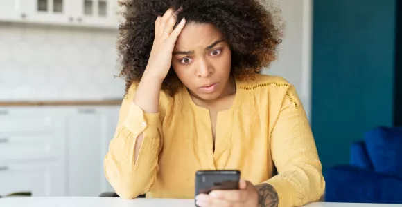 femme qui regarde son téléphone en panique 