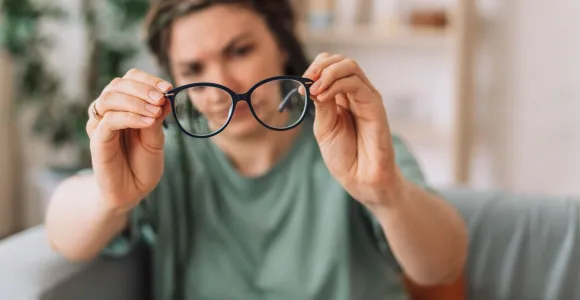 femme qui regarde ses lunettes