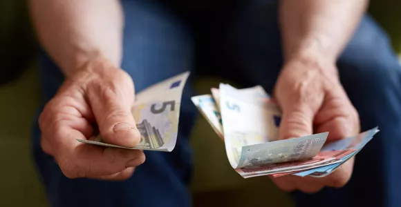 Des mains tiennent des billets d'Euros