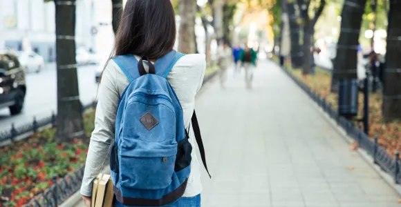Adolescente marchant dans la rue et portant un sac à dos