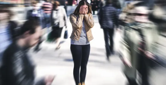 femme dans une foule les mains sur le visage