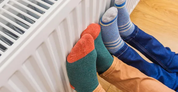 Deux personnes mettent leurs pieds en chaussettes sur le radiateur