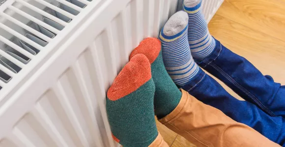 Deux personnes mettent leurs pieds en chaussettes sur le radiateur