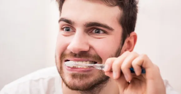 Un homme se brosse les dents