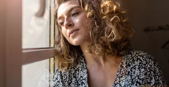 femme qui regarde par la fenêtre