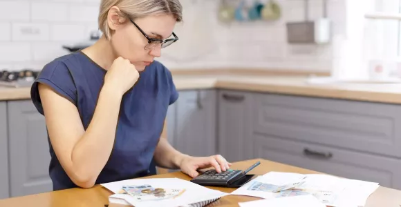 Une femme vérifie des documents à l'aide d'une calculatrice