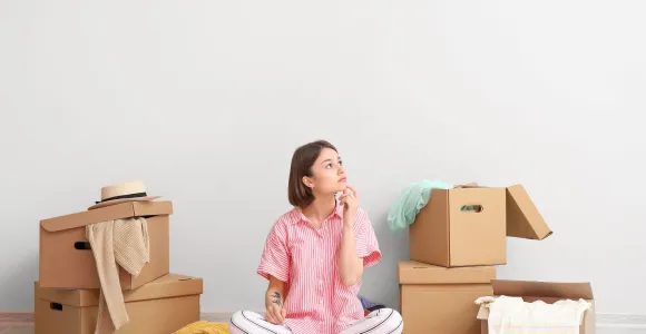 Jeune fille assise au milieu des caisses 