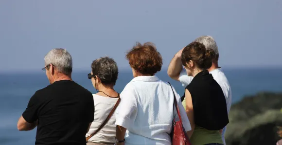 Un groupe de retraités observe une étendue d'eau