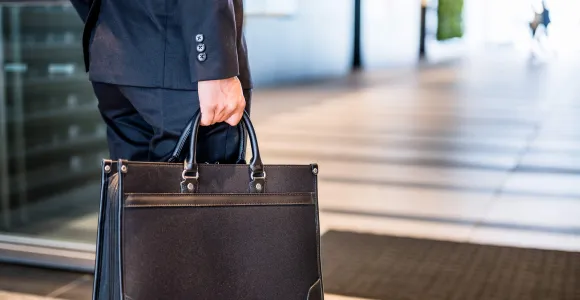 Un homme tient un porte-document en cuir