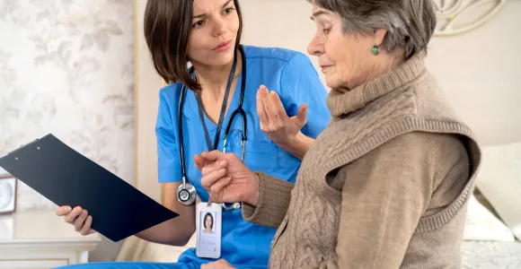 Une infirmière discute avec une dame âgée