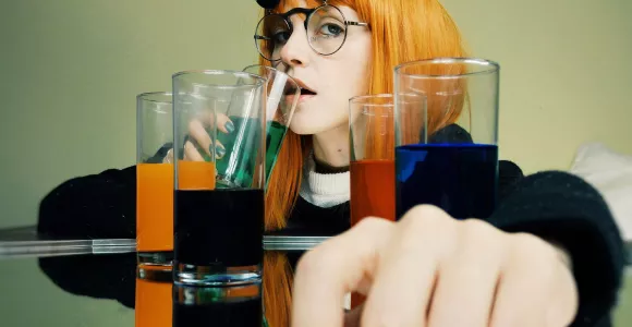 Une jeune femme boit un cocktail alcoolisé