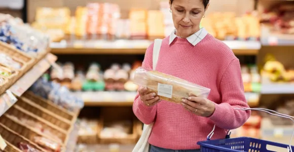 Une femme consulte l'étiquette d'un pain en magasin