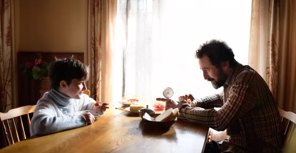 Un père et son fils prennent le petit déjeuner à table