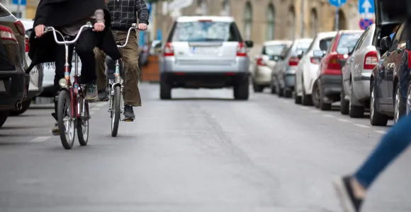 Deux vélos circulent dans une rue avec des voitures