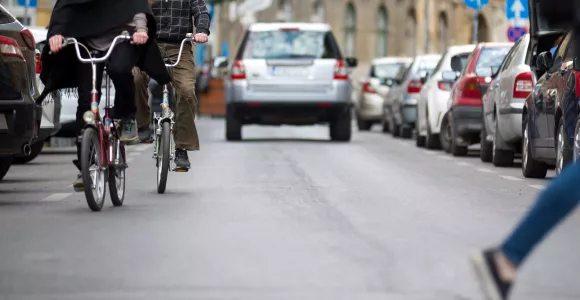 Deux vélos circulent dans une rue avec des voitures