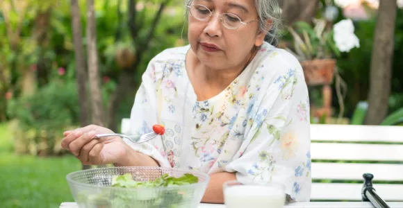 Vielle dame qui mange une salade