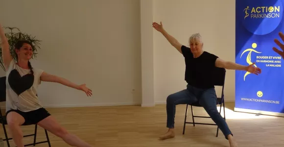 Deux femmes dansent assises sur leur chaise