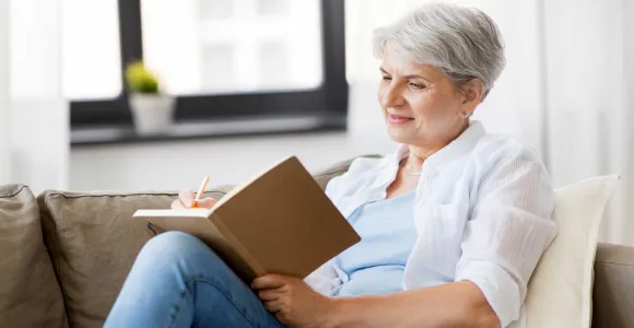 Une dame âgée écrit dans un carnet