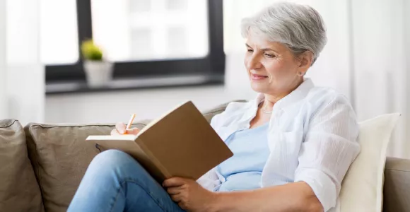Une dame âgée écrit dans un carnet