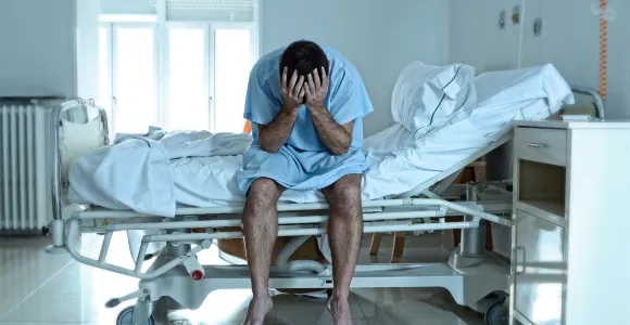 Un patient désespéré sur un lit d'hôpital