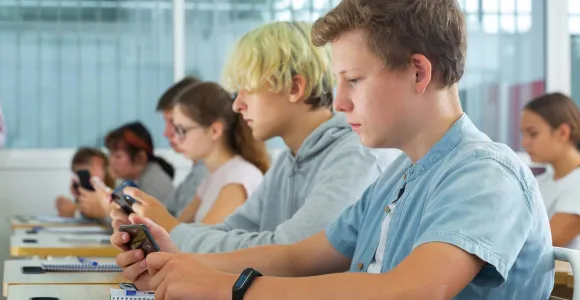 Un élève sur son smartphone dans une classe de cours