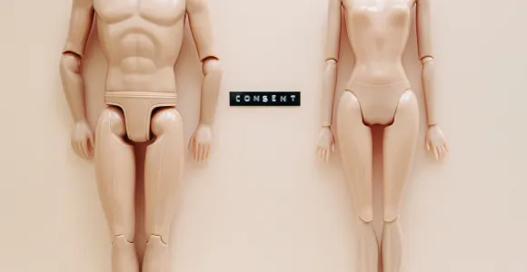Deux poupées Barbie nues avec le mot "Consent"