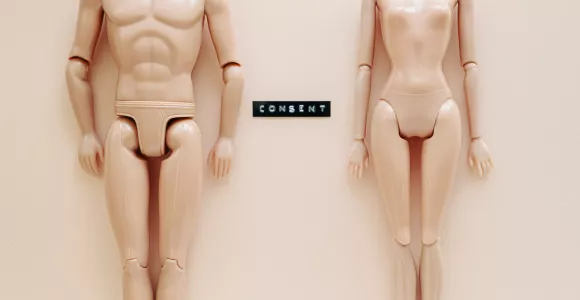 Deux poupées Barbie nues avec le mot "Consent"