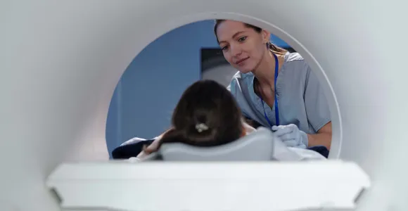 Une patiente est positionnée dans un IRM par une infirmière
