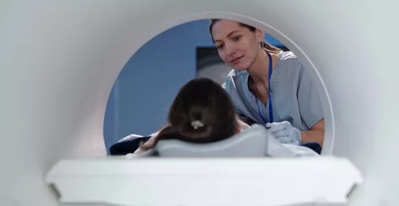 Une patiente est positionnée dans un IRM par une infirmière