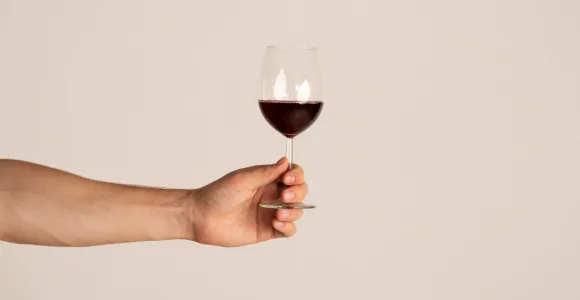 Un homme tient un verre de vin rouge