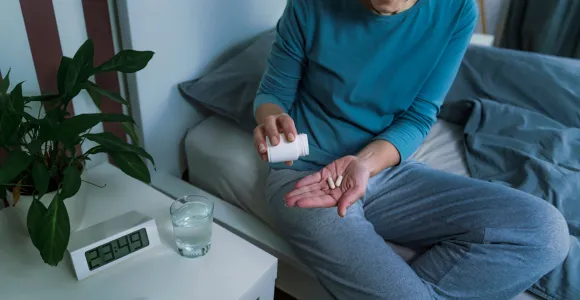 Une femme prend de la mélatonine pour dormir et éviter les insomnies