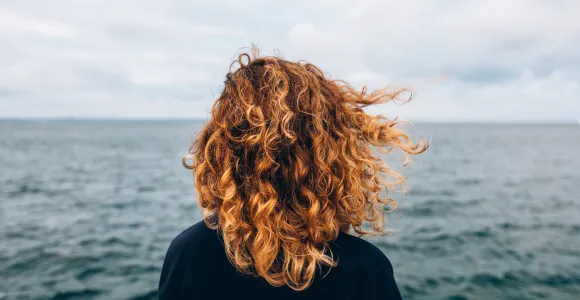 Une femme regarde la mer et son horizon