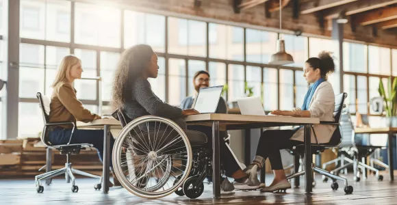 personnes en chaise roulante sur un plateau de travail avec ses collègues