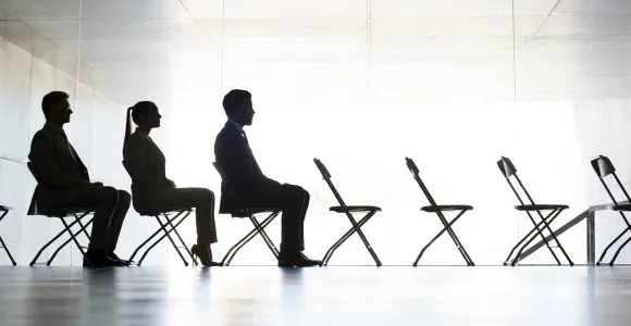 deux hommes et une femme sont assis sur des chaises pliantes