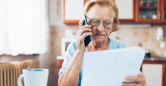 Un monsieur scrute le document qu'il doit compléter pour son assurance