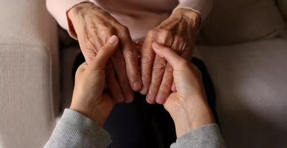 main d'une personne âgée et plus jeune se tenant en signe de solidarité