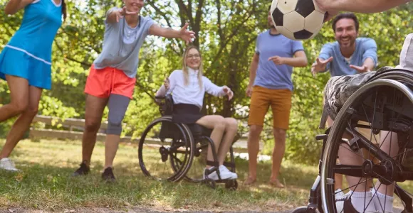 Des personnes valides et en situation de handicap pratiquent ensemble une activité avec un ballon.