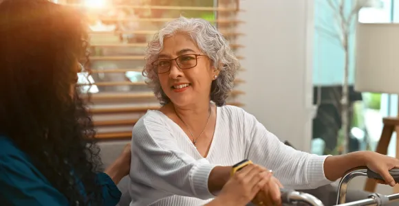 Une dame assise devant une tribune sourit à une autre personne