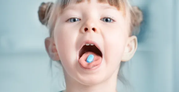 une petite fille a un médicament sur la langue
