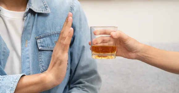 un  homme refuse un verre d'alcool