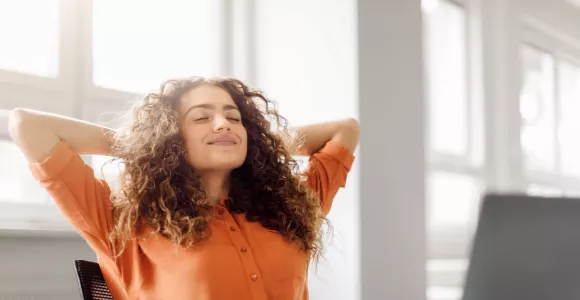 Une femme respire en cohérence cardiaque au bureau, pour réduire son stress