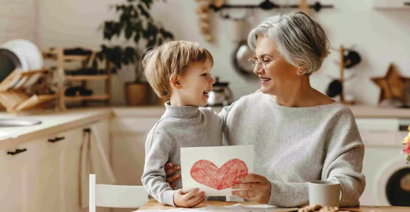 Une femme et son petit fils regardent un dessin avec un coeur