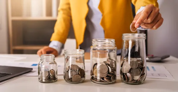 plusieurs bocaux plus ou moins remplis avec de l'argent 