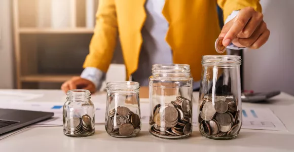 plusieurs bocaux plus ou moins remplis avec de l'argent 