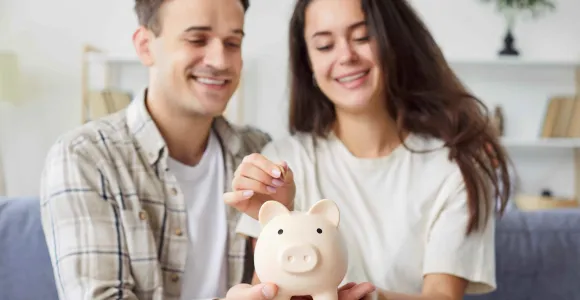 Un jeune couple pèse une tirelire en forme de cochon