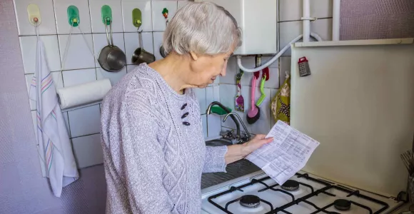 Une dame âgé allume sa gazinière